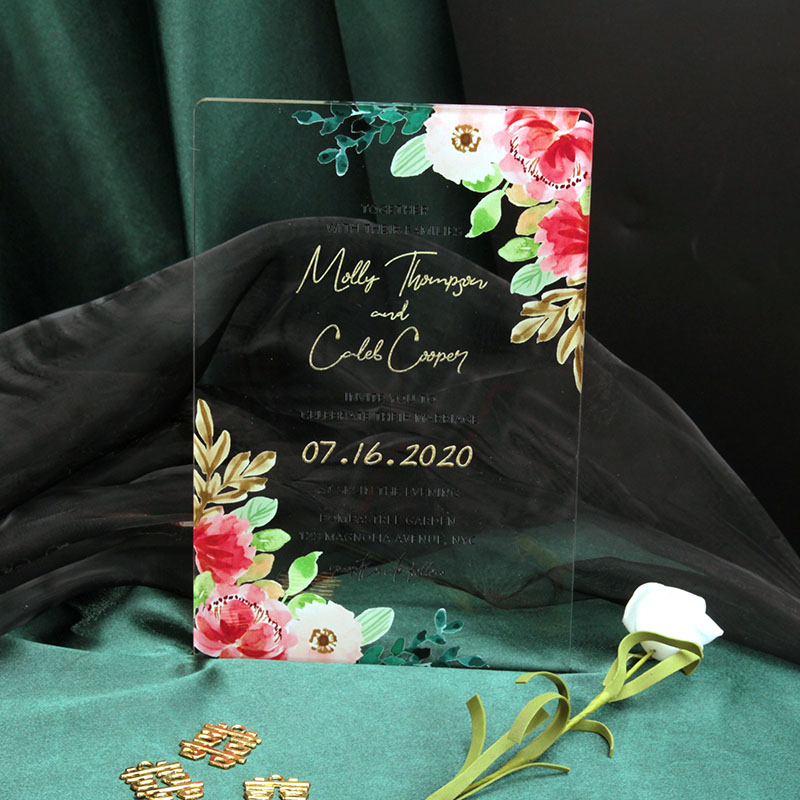 Crystal clear acrylic wedding invitation HPA290 with vibrant pink watercolor flowers and metallic gold text inside a translucent transparent envelope