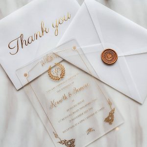 Crystal clear acrylic wedding invitation HPI298 with metallic gold foliage leaf borders and elegant script text inside a transparent envelope
