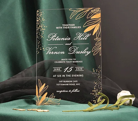 Crystal clear acrylic wedding invitation HPA289 with gold metallic text and leaf print sitting inside a transparent envelope