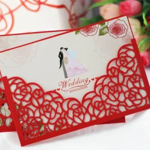 red laser cut wedding invitation with rose floral border and romantic couple illustration